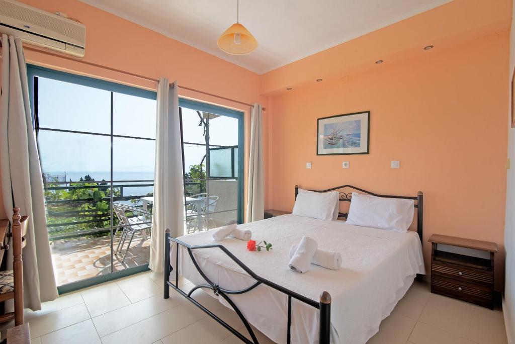 a bedroom with a bed and a large window at Andromaches large apartment 2 in Corfu