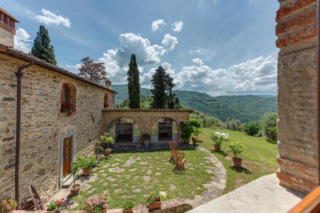an external view of a stone house with a garden at La Casa di Colle in Dicomano