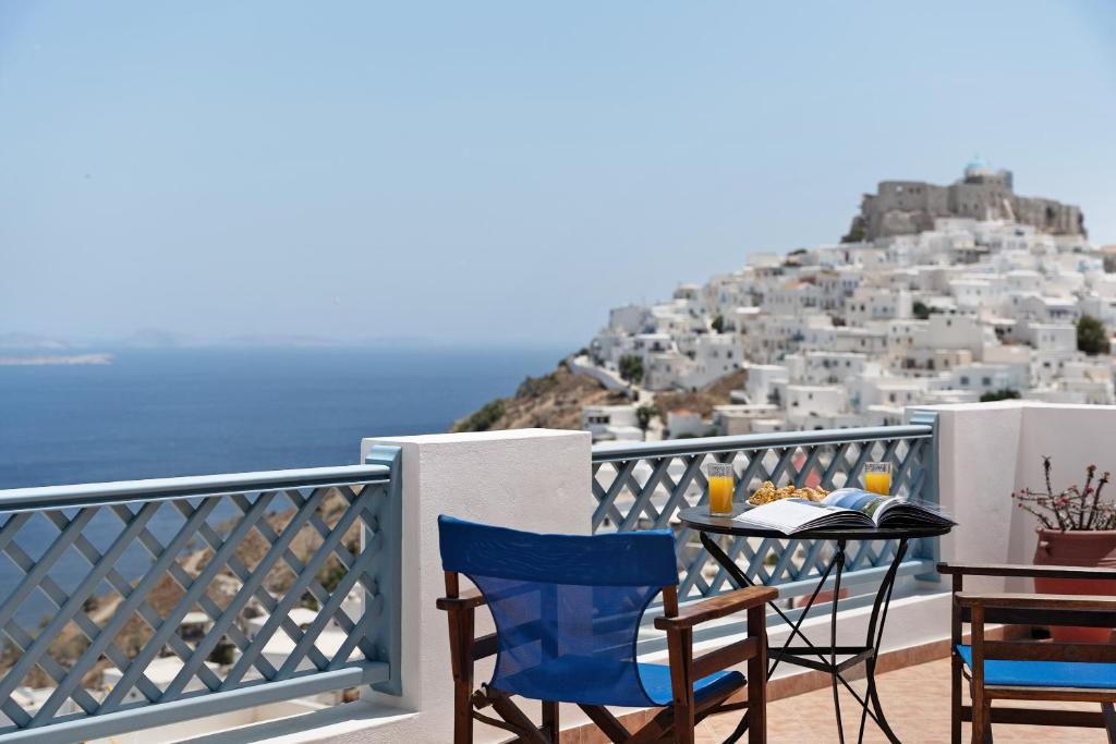 a table and chairs on a balcony with a view at Lefkanthemo Apartment in Astypalaia