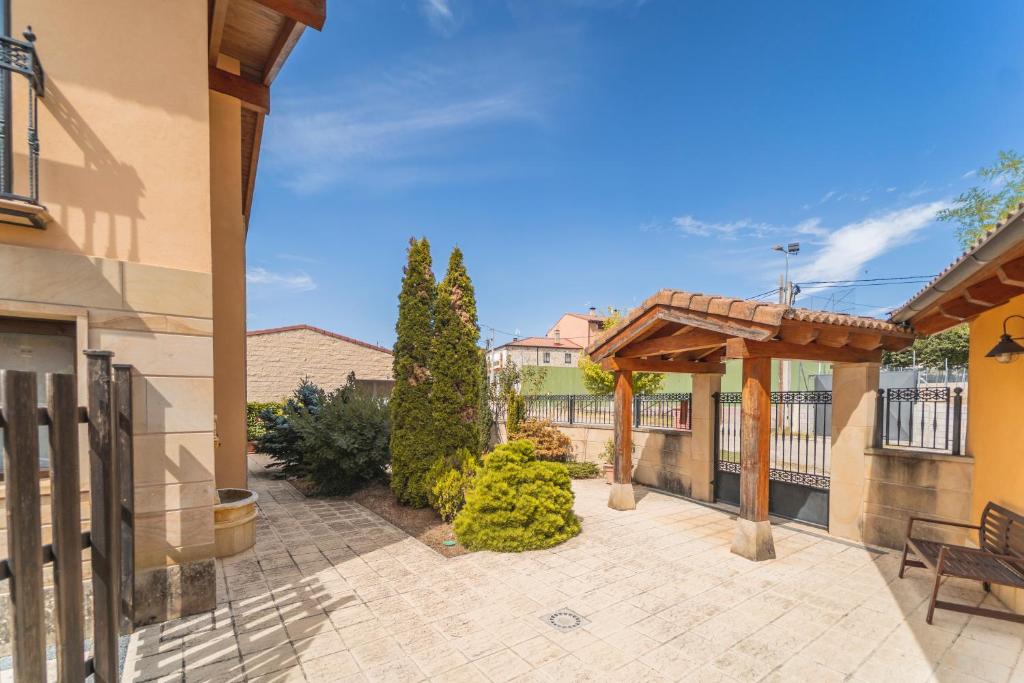 an outdoor patio with a wooden pergola at La Dehesa de Santa Ursula in Espeja de San Marcelino