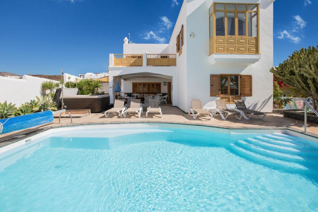 a large swimming pool in front of a house at Villa Lea in Puerto del Carmen