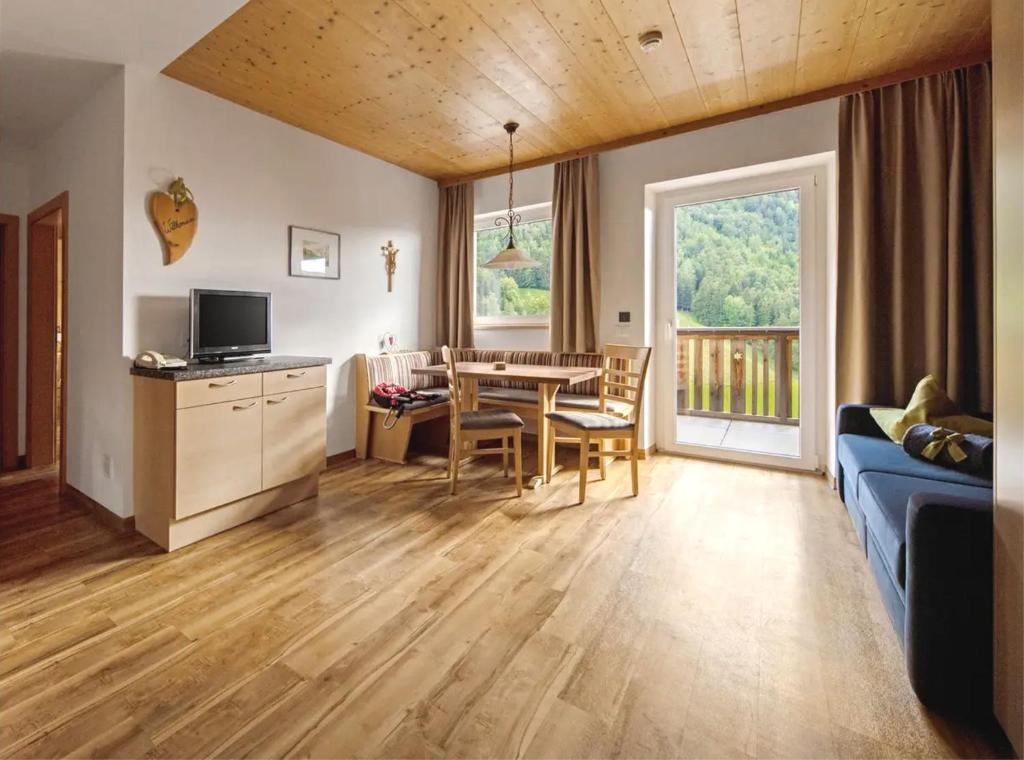 a living room with a blue couch and a table at Sonnleiten der kleinen Bären 8 in Collepietra