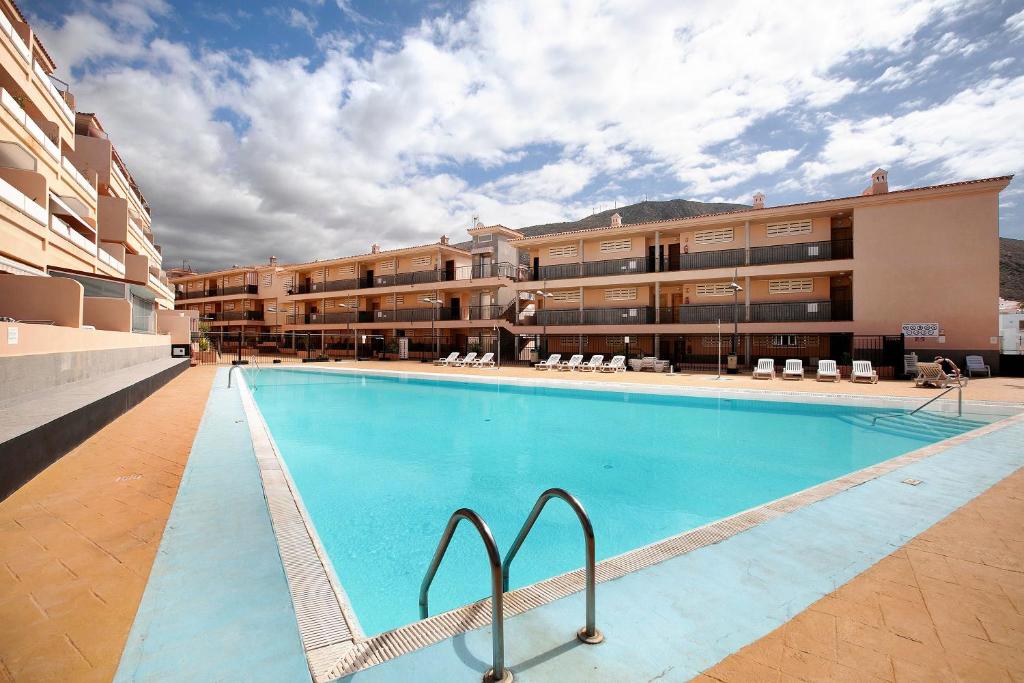 a large swimming pool in front of a building at Ático Los Seres in Los Cristianos