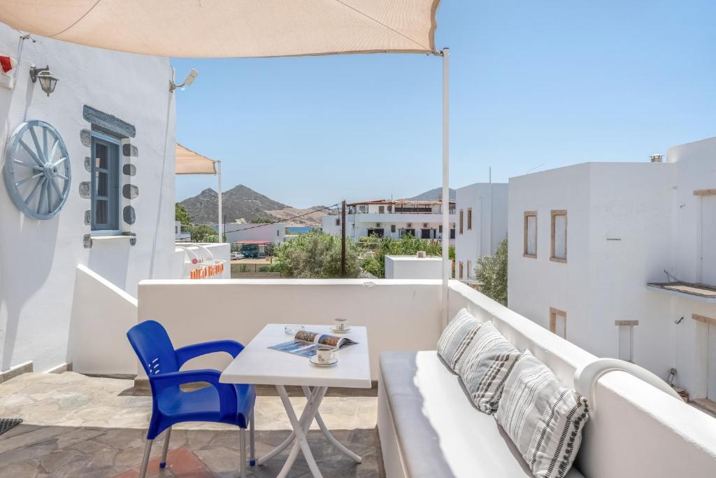 a balcony with a couch and a table and chairs at Pico Bello Patmos 18 in Patmos