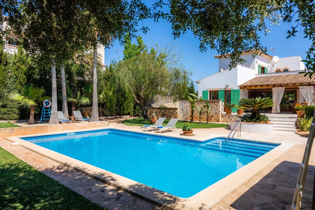 a swimming pool in the backyard of a house at Villa Rico in Portocolom