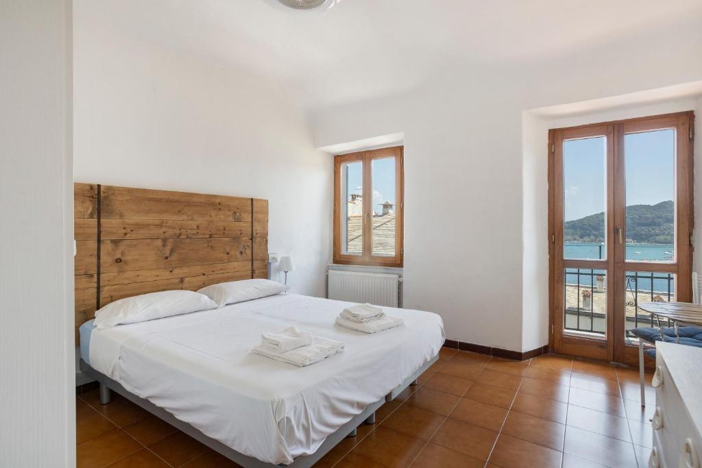 a bedroom with a large white bed with two towels on it at La ca bela in Portovenere