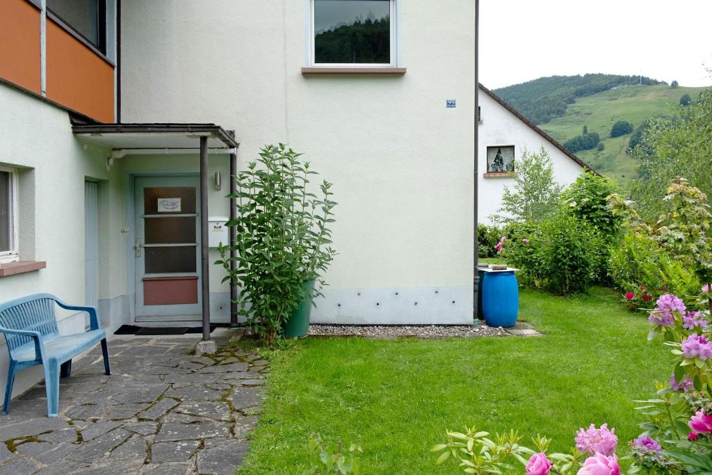 a white house with a blue bench in a yard at Haus Marion in Todtnau
