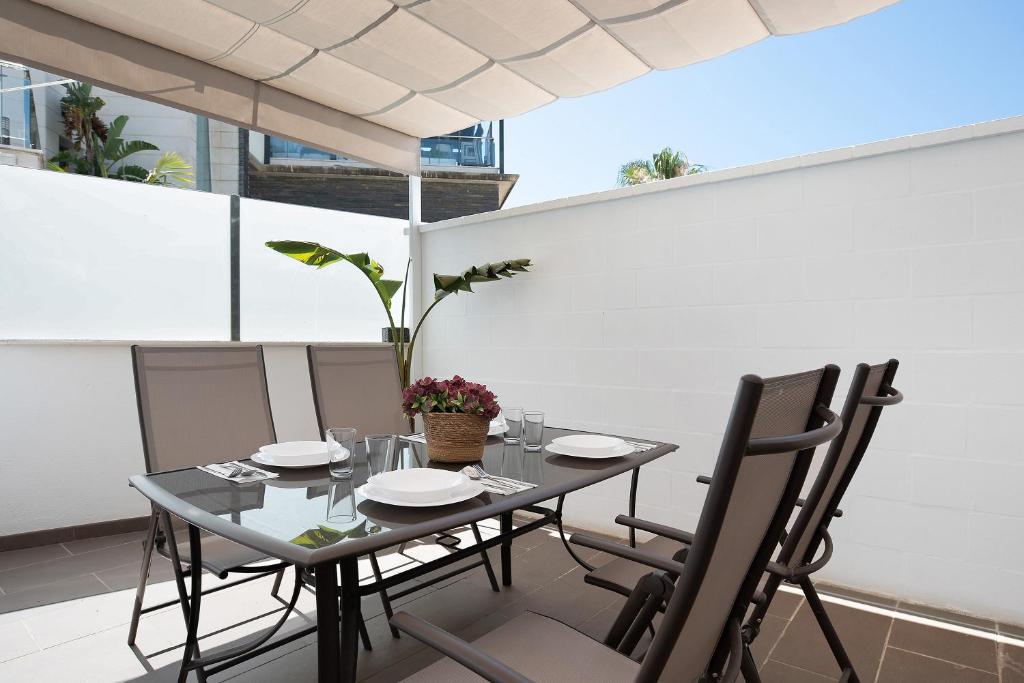 a table and chairs on the balcony of a building at Mariola in Novo Sancti Petri