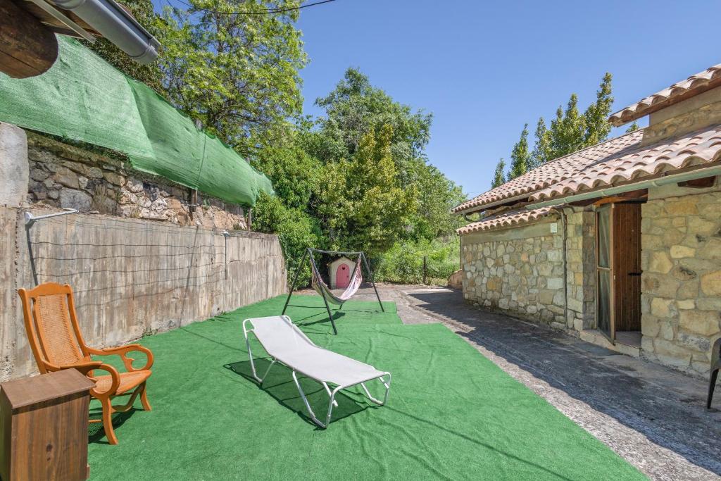 a patio with two lawn chairs on a green blanket at Hospitalillo in Sant Corneli de Cercs 