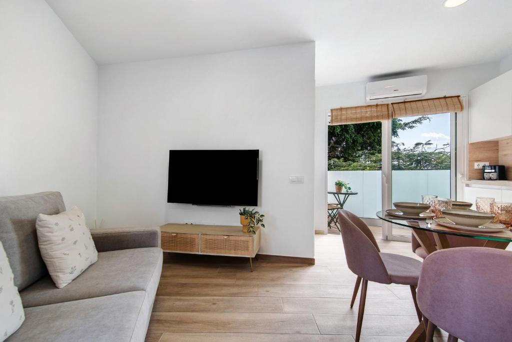 ein Wohnzimmer mit Sofa und Tisch in der Unterkunft Flamboyan 2 in Telde
