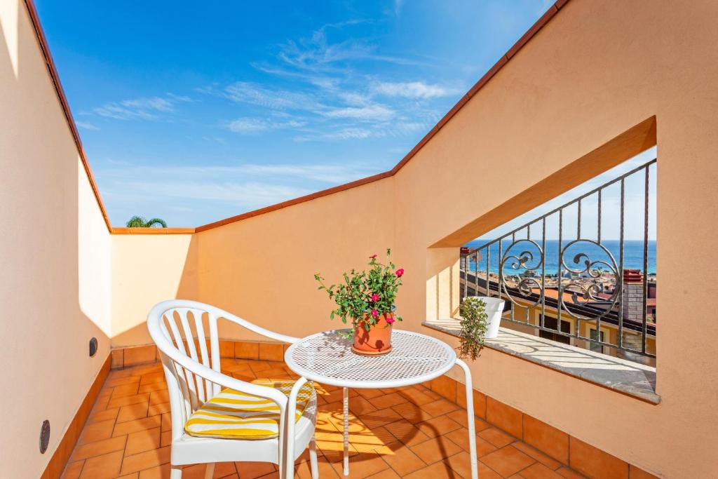 a balcony with a table and chairs and a window at The Amphora Lodging in Furci Siculo