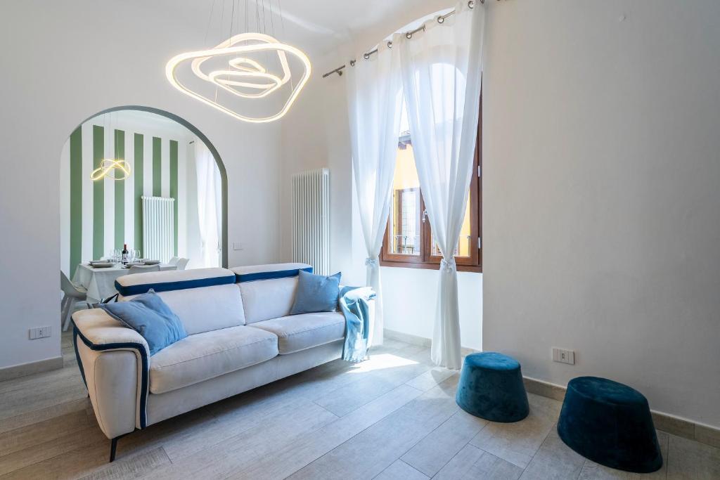 a living room with a white couch and two blue stools at La Domus Firenze in Florence