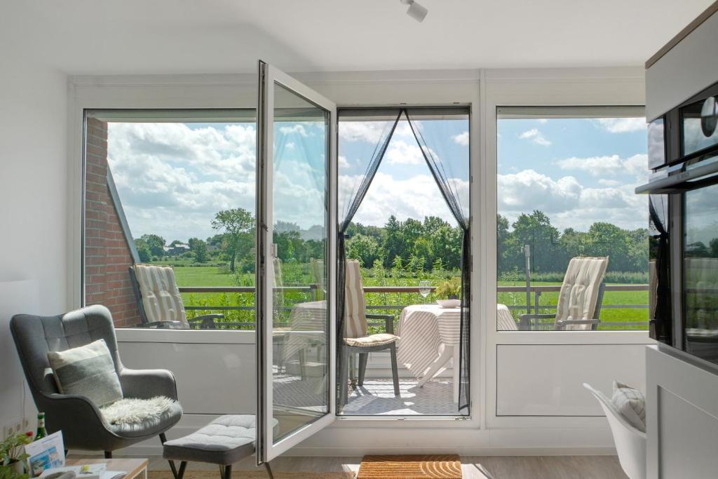 a living room with sliding glass doors leading to a patio at Deichblick - in 5 min am Meer in Wangerland