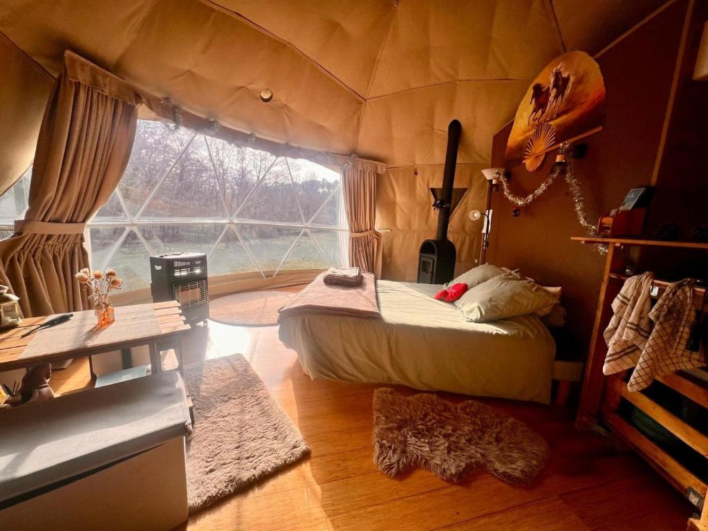 a room with a bed in a tent with a window at La Cabane aux Chevaux in Varages