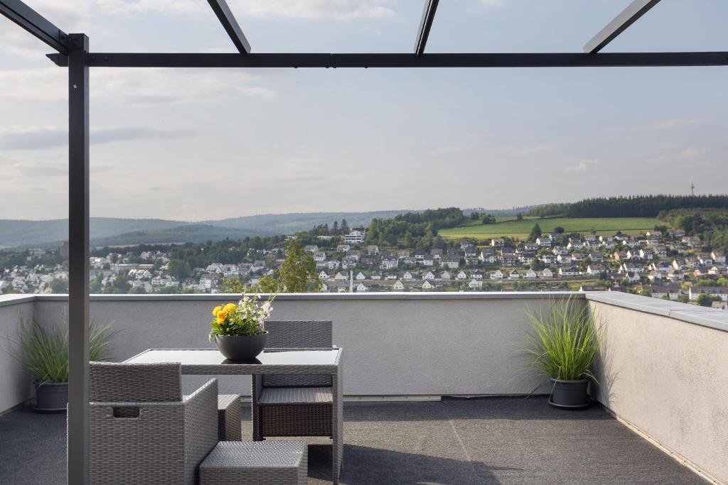 a balcony with a table and chairs and a view at Ferienwohnung Zum Hasen in Meschede