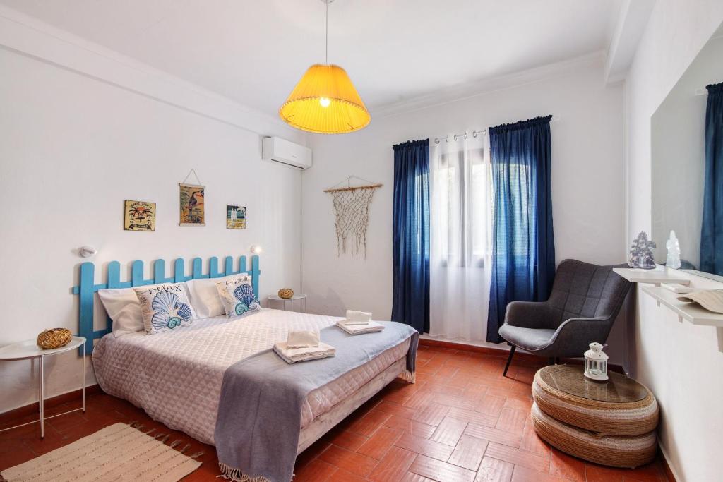 a small bedroom with a bed and a chair at Casa Amarela in Tavira