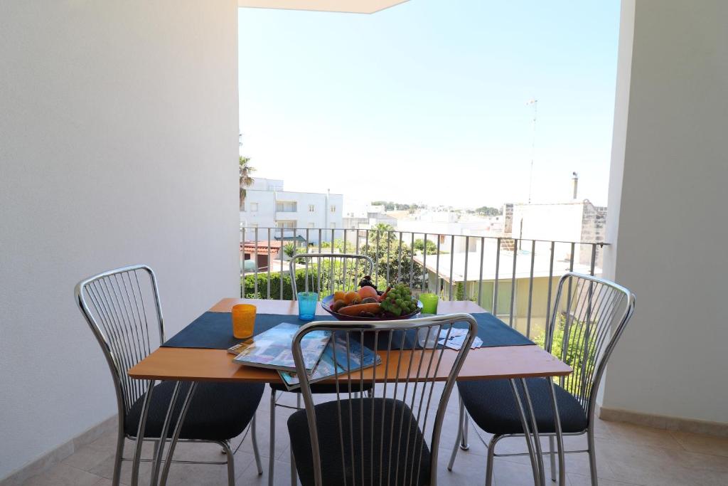 a table with chairs and a plate of fruit on it at Casa Rossana a Otranto in Otranto
