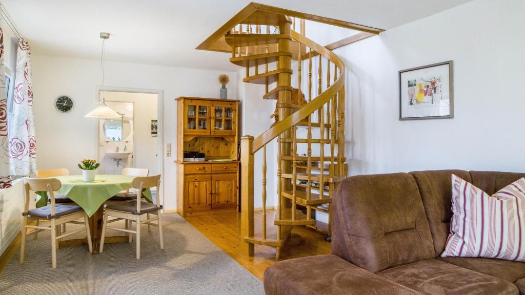 a living room with a spiral staircase and a table at Ferienwohnung Ipser in Vogtsburg