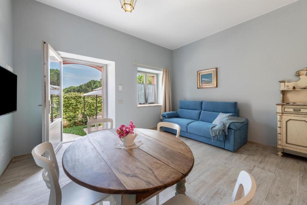 a living room with a wooden table and a blue couch at Abaye 2 Pinot - Charm Adults Only in Soiano del Lago