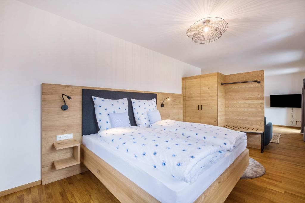 a bedroom with a large bed with a wooden headboard at Ferienwohnung Rosa in Gilching