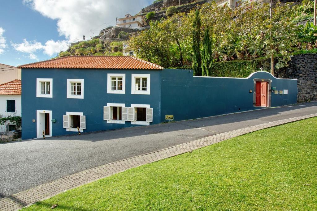 a blue house on the side of a road at Calheta Beach House T2 in Calheta