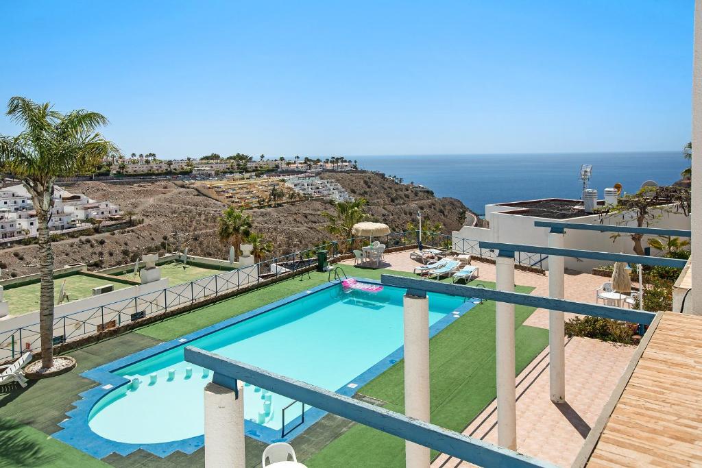 a view of the pool from the balcony of a villa at Rainbow Amadores in Mogán