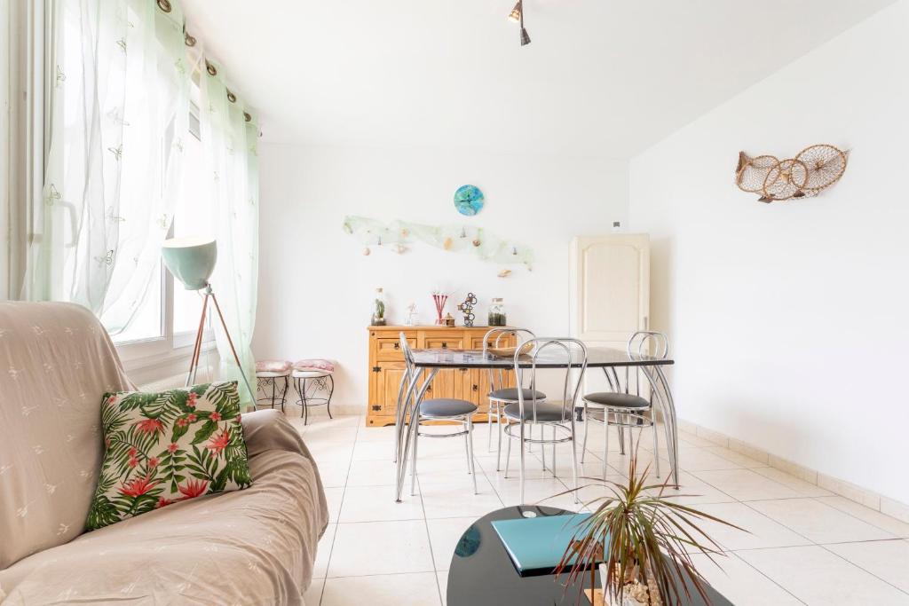 a living room with a couch and a table at Jolie maison mitoyenne in Concarneau