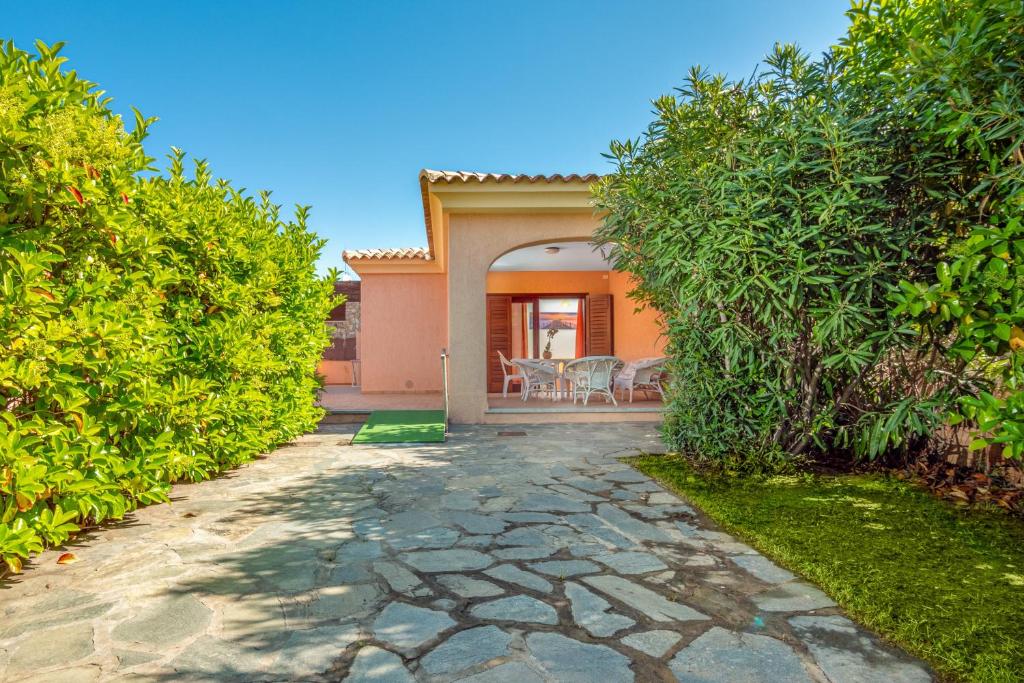 a stone walkway leading to a house with trees at Villetta Bifamiliare 2 in San Teodoro