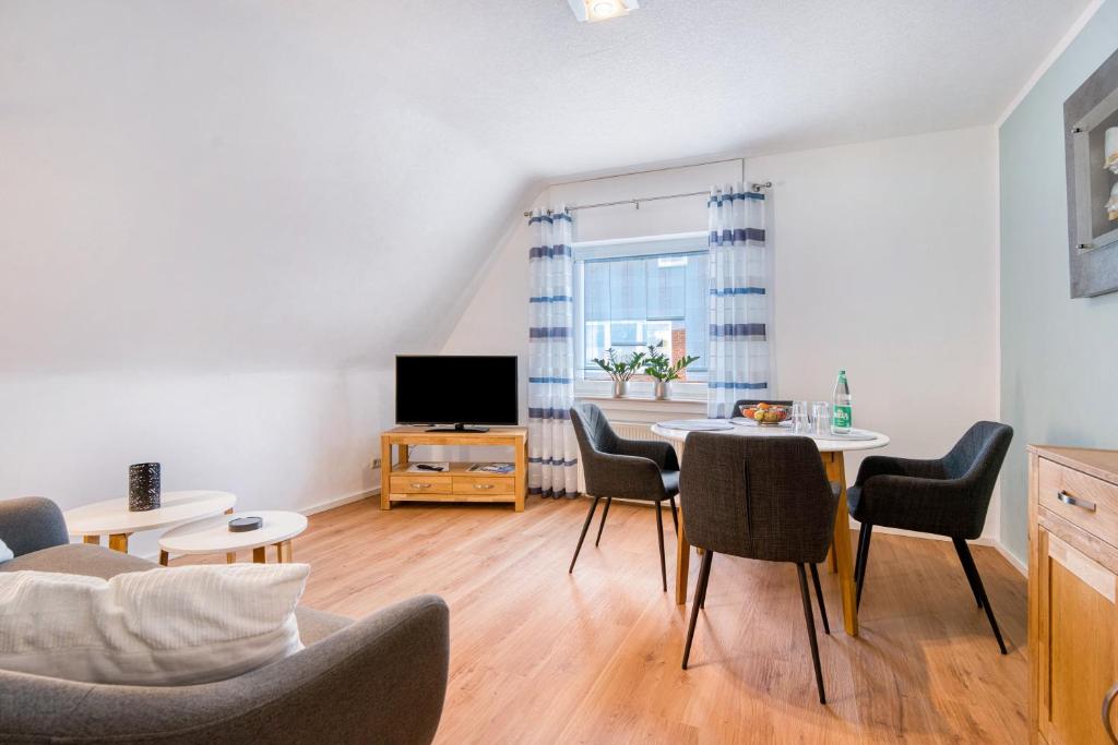 a living room with a table and chairs and a tv at Ferienwohnung Langenhorst in Raesfeld