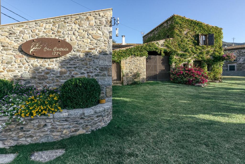 a stone building with a sign that reads the garden inn at Can Cortada in Cantallops