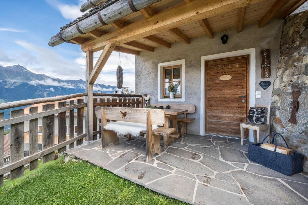 a wooden deck with a table and a bench at Thaler-hof Ferienhaus Fichtnhittl in Lagundo