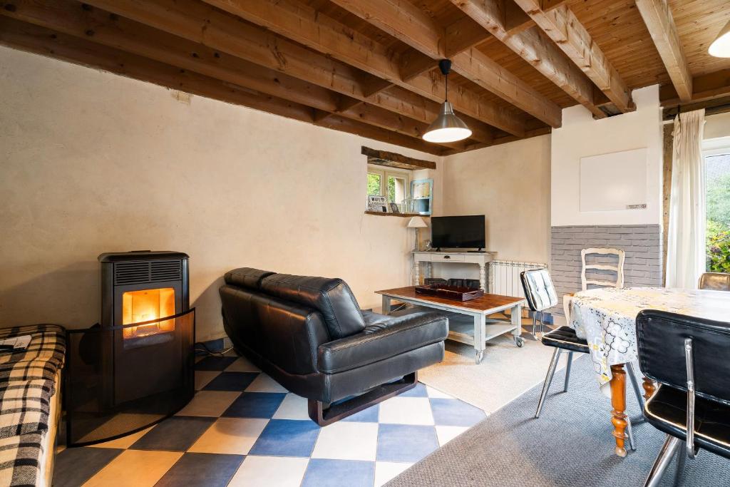 a living room with a leather couch and a fireplace at Gîte La Malcotais in Noyal-Châtillon-sur-Seich