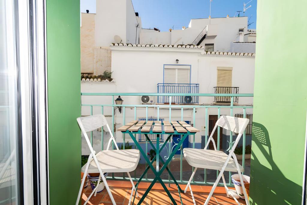 a balcony with two chairs and a table on a balcony at Casa de Arte in Torrox
