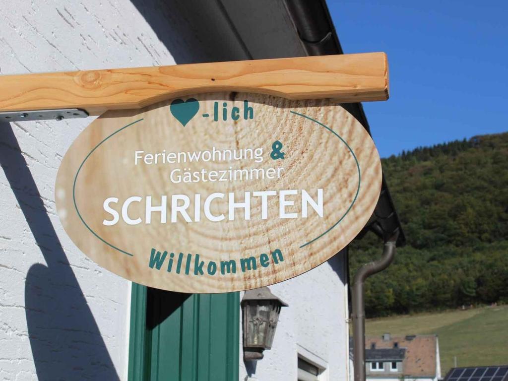a wooden sign for a restaurant on a building at Ferienunterkunft Schrichten in Schmallenberg