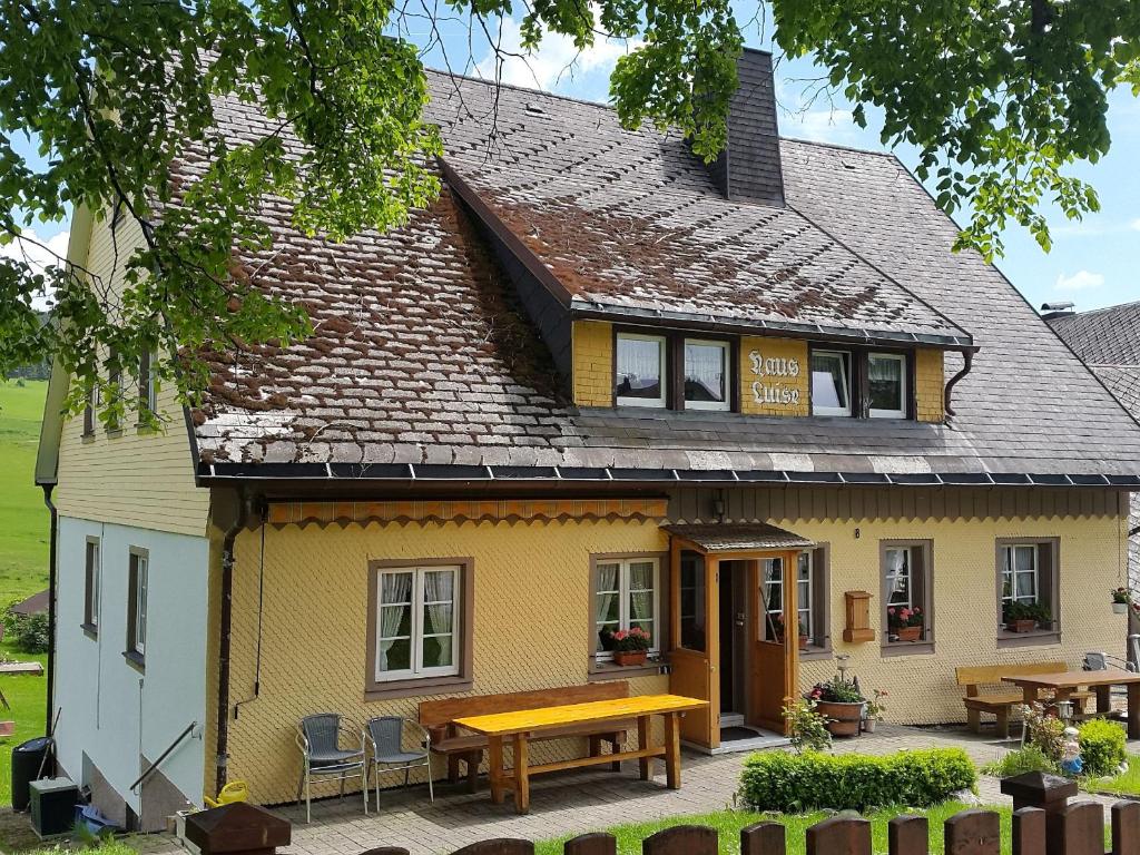 a yellow building with a bench in front of it at Haus Luise in Lenzkirch in Lenzkirch