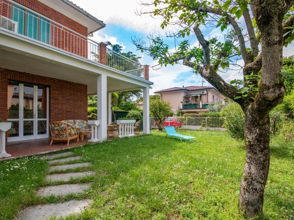 a house with a yard with a tree at Casa Camilla in Manerba del Garda
