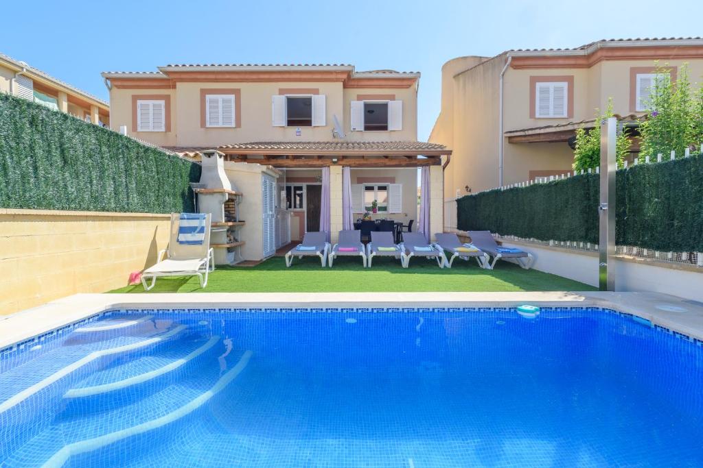 a swimming pool in front of a house at Estrella de mar verde in Port d'Alcudia