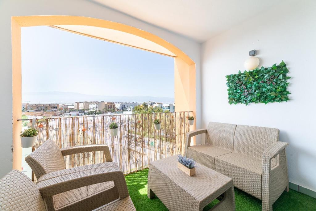 a balcony with chairs and a table and a large window at Apartamento residencial Fénix in Roquetas de Mar