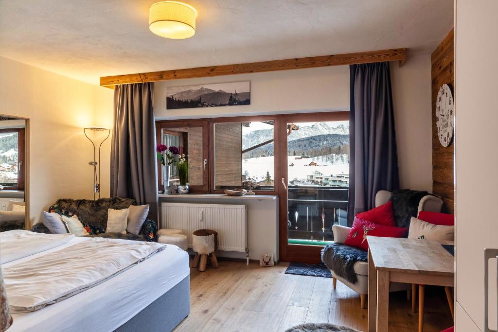 a hotel room with a bed and a balcony at Haus Excelsior Top 36 in Seefeld in Tirol