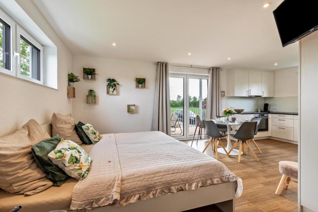 a bedroom with a large bed and a kitchen at Fewo Parkside S3 - 8Min Legoland in Günzburg