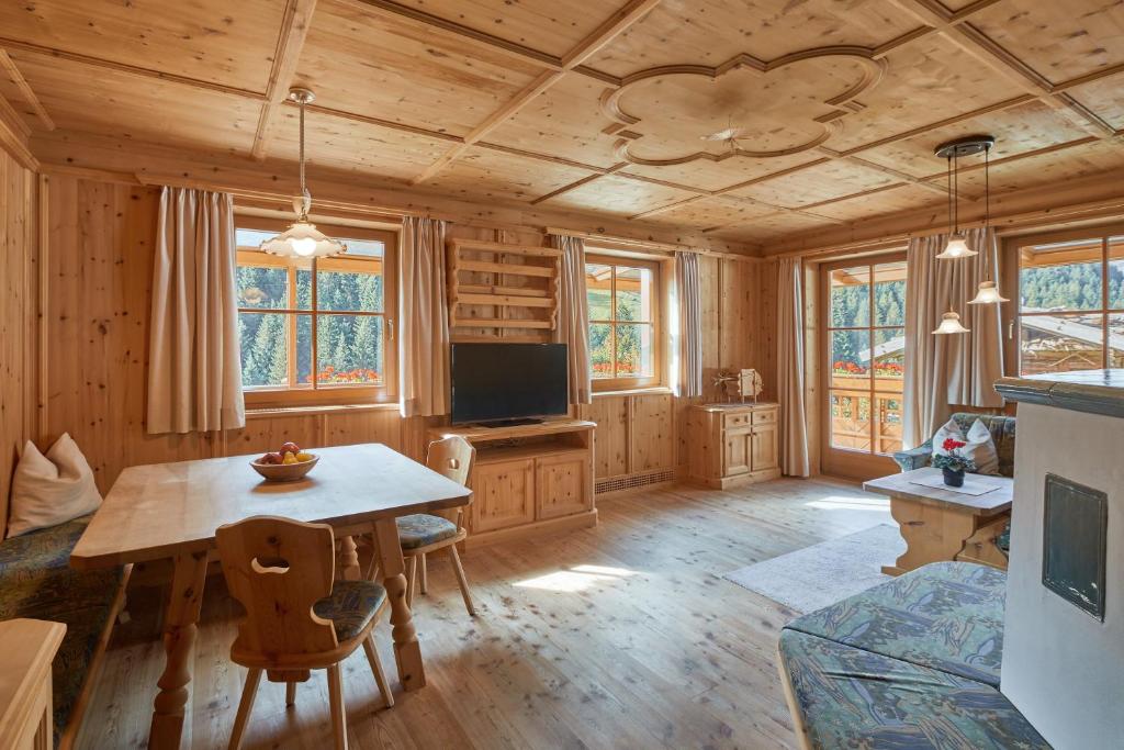 a dining room with a table and a tv at Blasigsuite Blasighof in Racines
