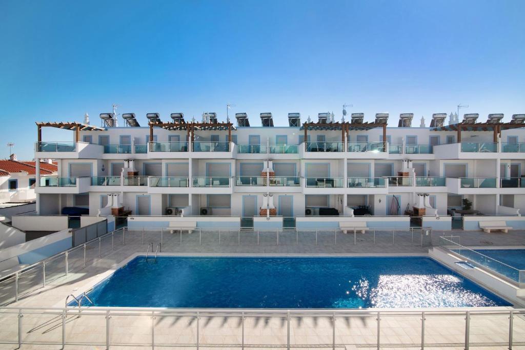 a large building with a swimming pool in front of it at Numar Residence Villa Z in Manta Rota