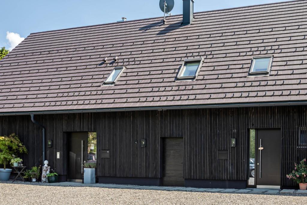 a brown building with two doors and a roof at La casa nel verde in Lindau