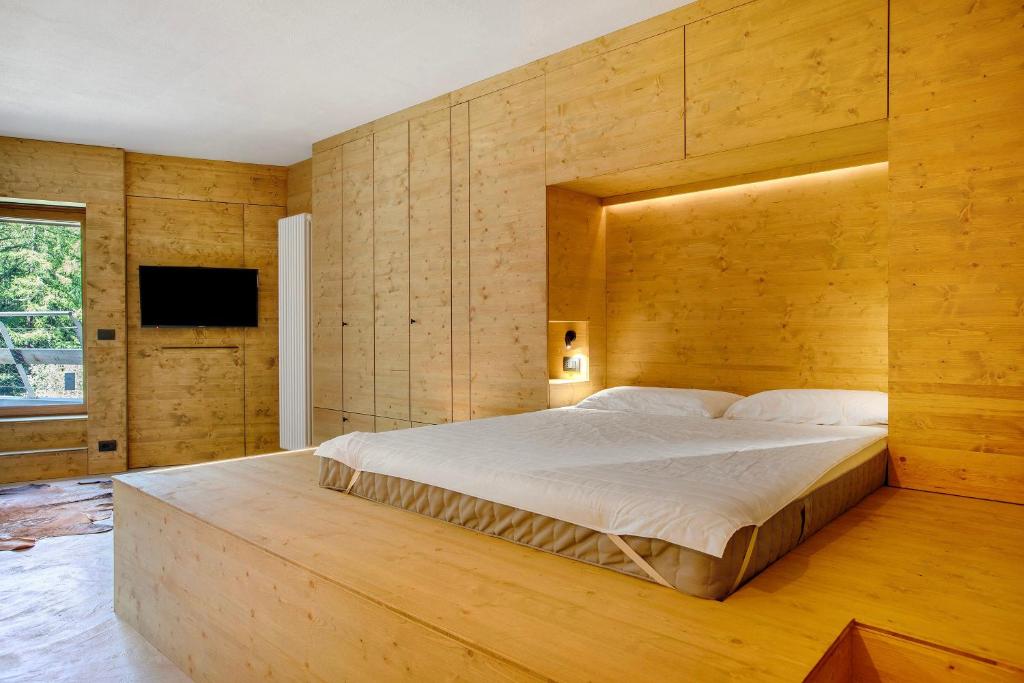 a bedroom with a large bed with a wooden wall at Secret Place - Pila Appartamenti in Pila