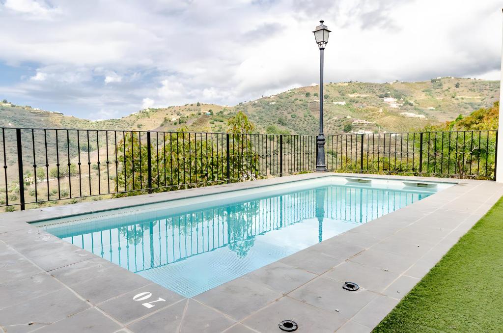 a swimming pool in a yard with a fence at Casa Jema in Torrox