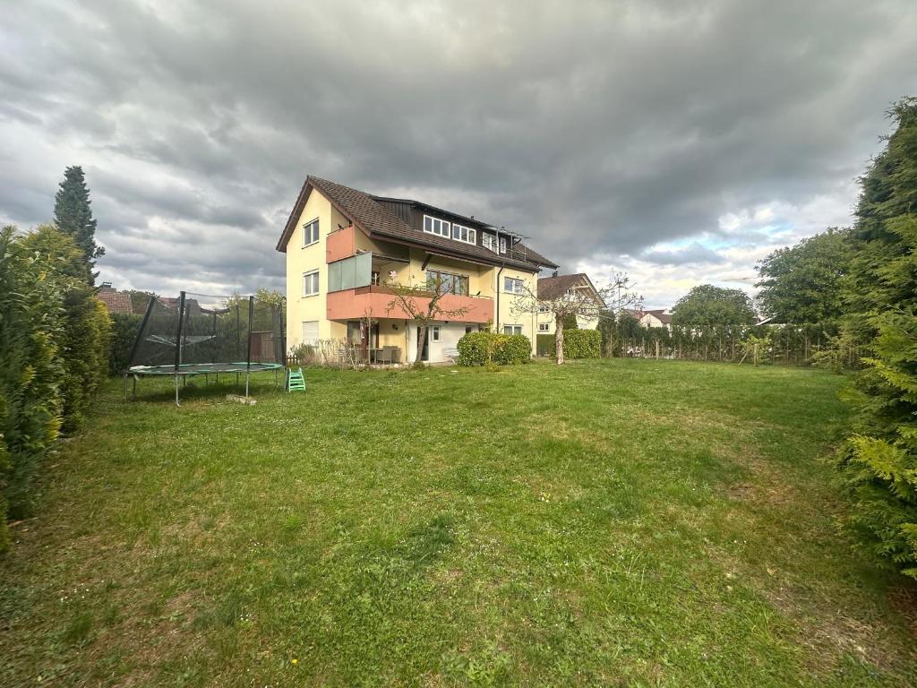 a large house in a field with a grass yard at Ferienwohnung Markelfingen in Radolfzell am Bodensee