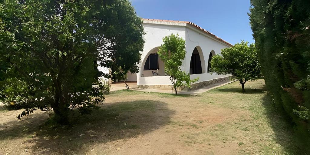 a white house with trees in front of it at Las fuentes in Alcossebre