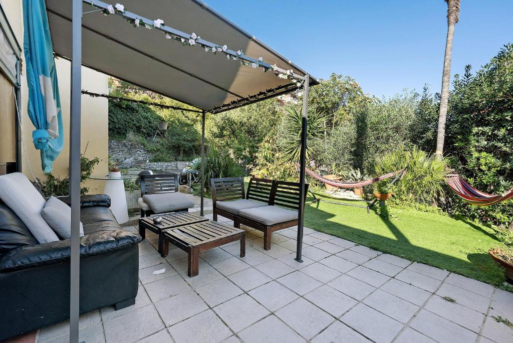 a patio with benches and a hammock in a yard at Botafogo in Chiavari
