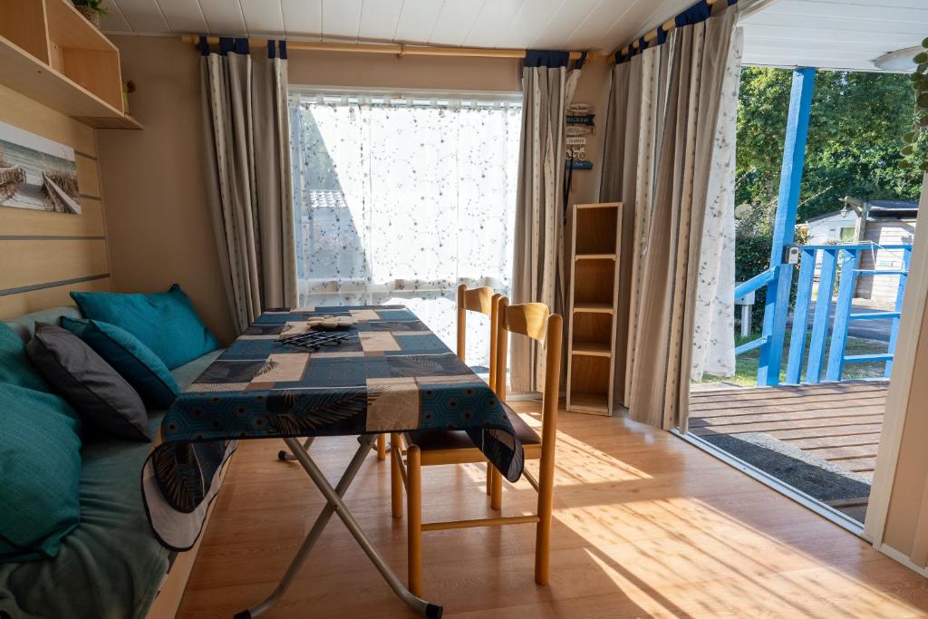 a room with a table and a couch at Mobilehome 4 personnes in Les Mathes