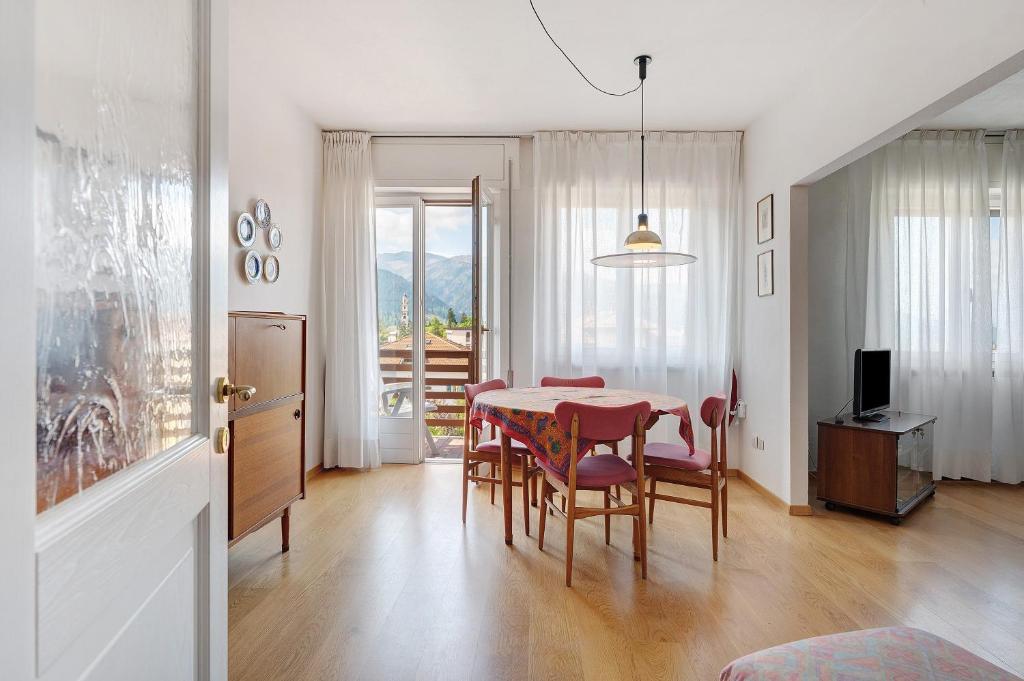 a dining room with a red table and chairs at Casa Marta in Cavalese